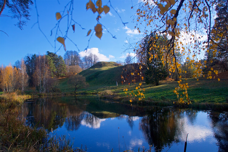 Burgberg Tērvete an einem Teich im goldenen Herbst