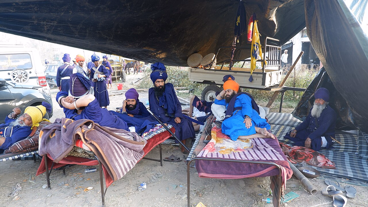 Nihang-Sikhs in blauen Gewändern ruhen im Camp