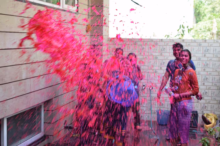 Mensen die Holi vieren, onder het roze poeder