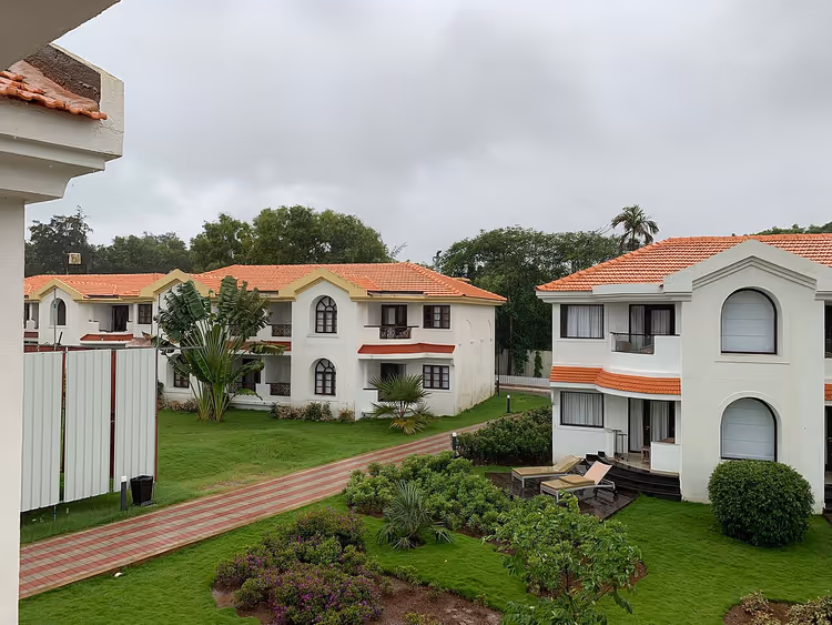 Kiremit çatılı ve çimli beyaz otel binaları