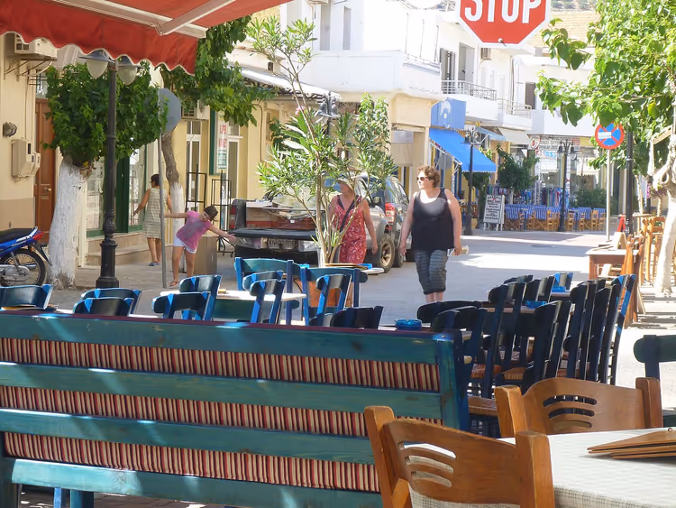 Straße in einem griechischen Ort mit Cafés und Menschen