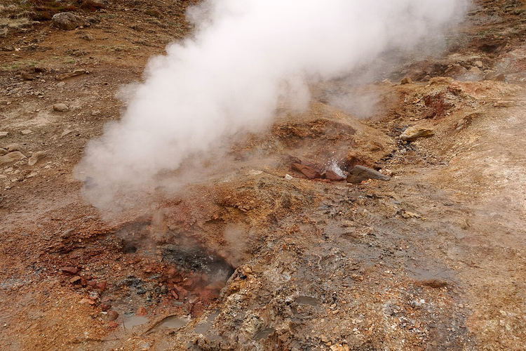 Stoom stijgt op uit een geothermische bron in Reykjadalur Vallei