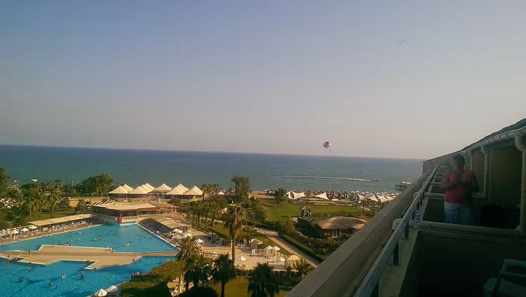 Bassenger og sjø fra en balkong på Kaya Belek Hotel