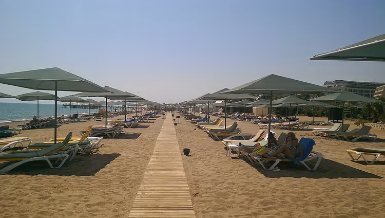 Şezlonglu ve şemsiyeli otel kumsalı