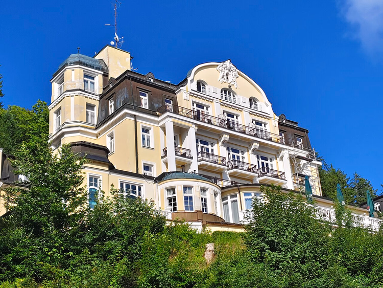Lys Hotel Royal-bygning i en skogkledd skråning