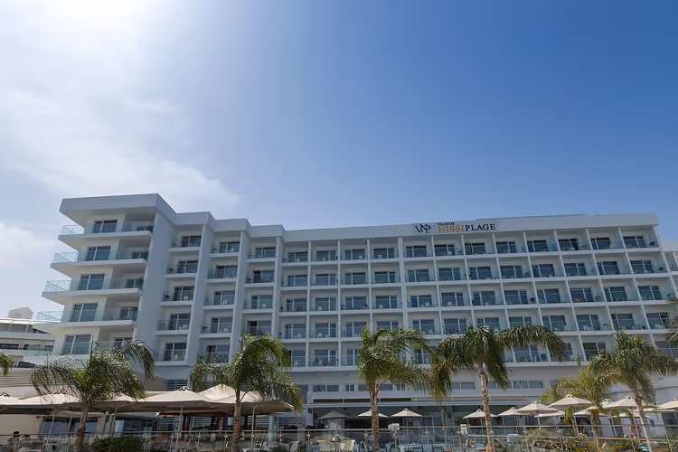 Palmiyelerle Vassos Nissi Plage Hotel'in beyaz binası