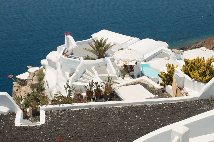 Weißes Hotel mit Pool über der Caldera in Oia