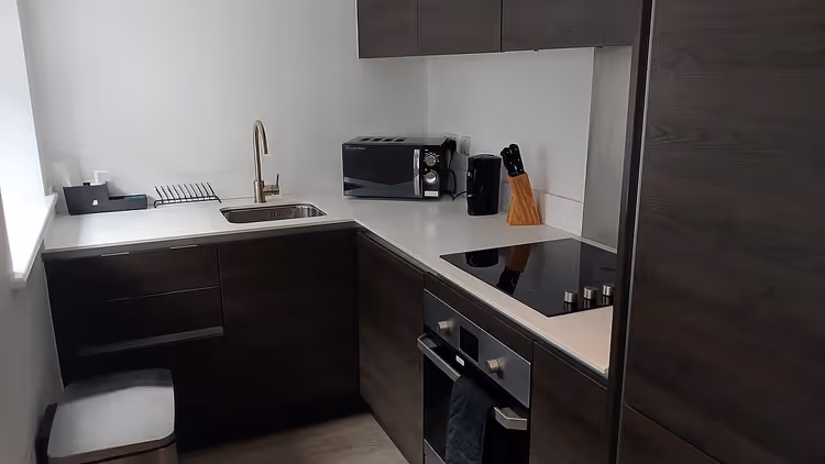 Ocak ve mikrodalga bulunan bir apart otel mutfağı