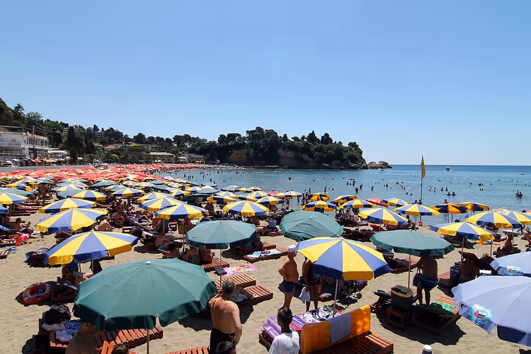 Mensen op het strand met kleurrijke parasols