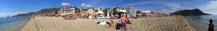 Panoramautsikt over en sandstrand med parasoller og hoteller