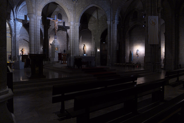 Nave gótica de uma igreja com um crucifixo sobre o altar