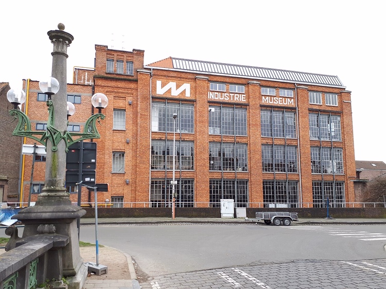 Bakstenen gevel van het Industriemuseum met bewegwijzering in Gent