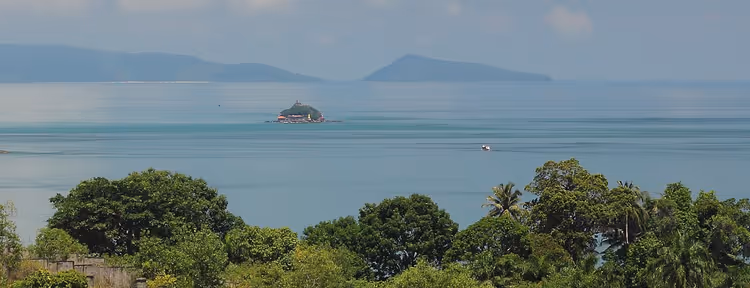 Deniz koyunda Koh Dek Koul adası, kıyıdan görünüm