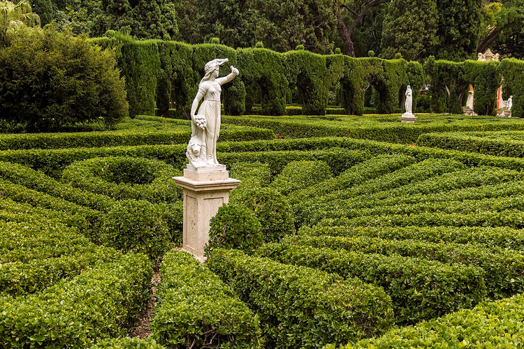Parterre de buxo com uma estátua de mármore no jardim
