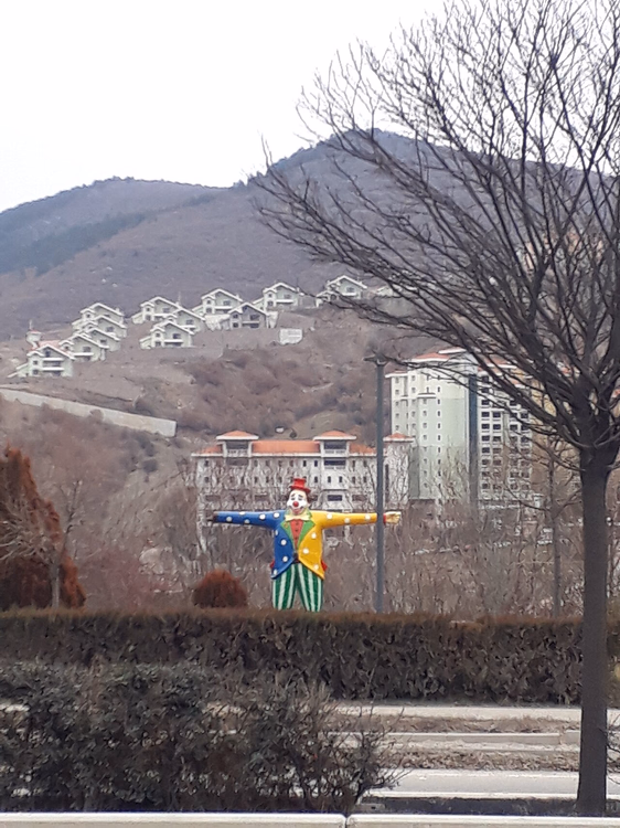 Klownfigur med hotellene i Kizilcahamam i bakgrunnen