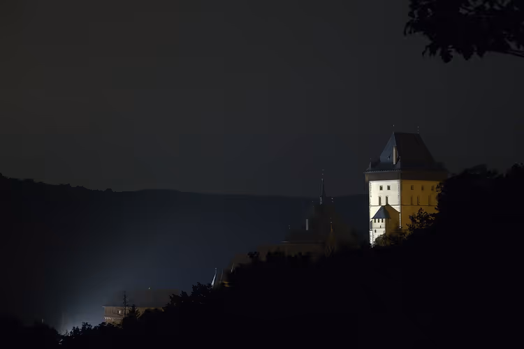 Verlichte Grote Toren van Kasteel Karlštejn bij nacht