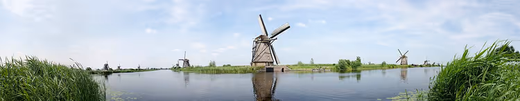 Panorama av Kinderdijk-kanalen med vindmøller og siv