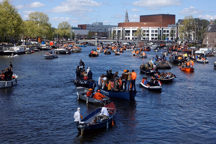 Båtar med människor i orange på Amstel