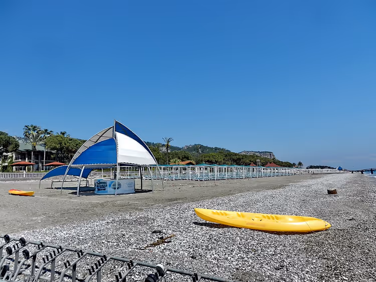 Kayak ve gölgelikli Kiris çakıl plajı