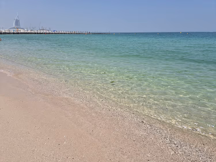 Jumeirah Plajı açıklarında turkuaz deniz, uzakta Burj Al Arab