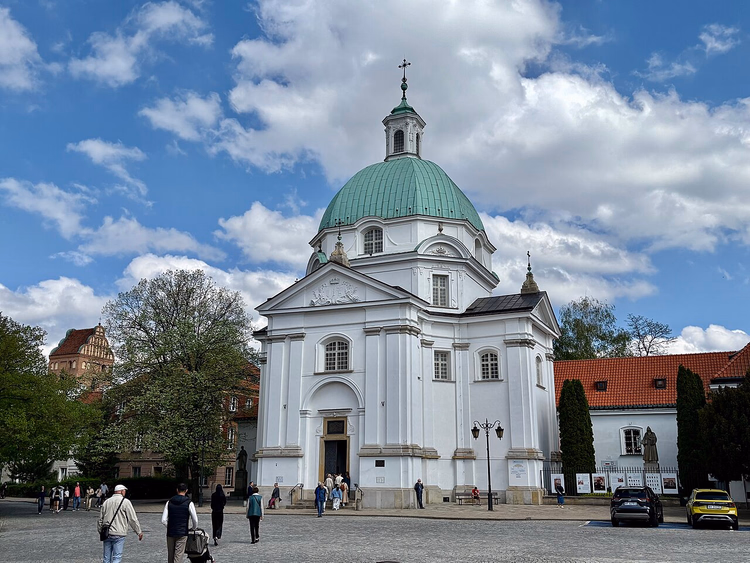 Hvit kirke med grønn kuppel på plassen