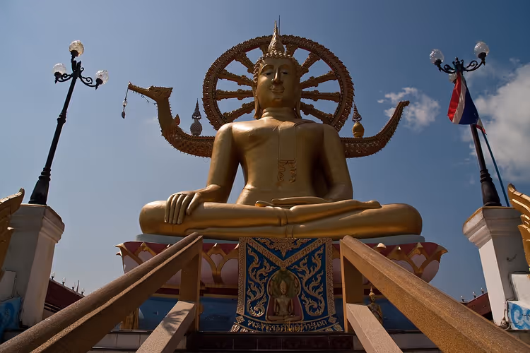 Gyllen statue av Den store Buddha mot himmelen