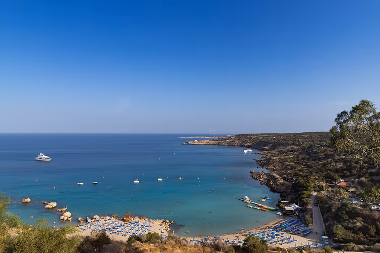 Baie de Konnos avec plage, parasols et eau turquoise