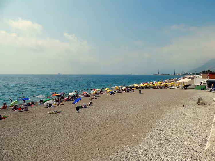 Галечный пляж Коньяалты с зонтами и морем