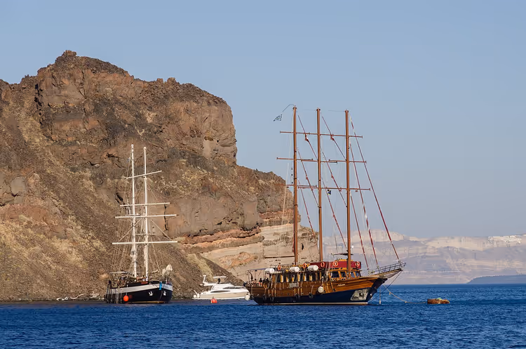 Segelboote in einer Bucht vor der felsigen Küste von Thirasia