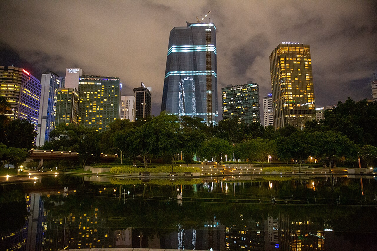 KLCC Parkı gölü kıyısında Kuala Lumpur'un gece gökdelenleri