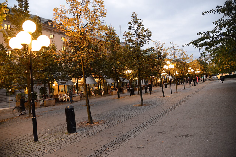 Abendlicher Weg im Kungsträdgården mit Laternen und Cafés