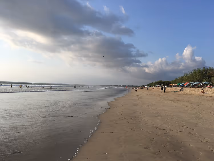 Zandstrand van Kuta met golven en mensen