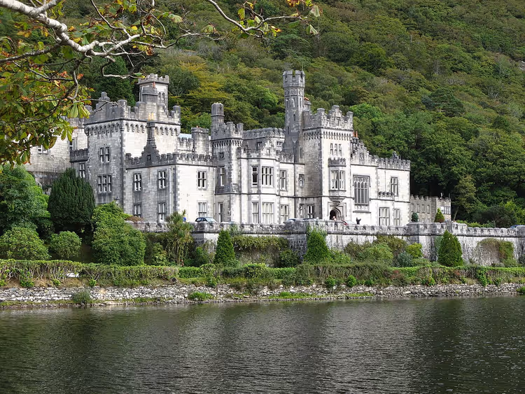 Kylemore Abbey aan een meer tussen beboste bergen