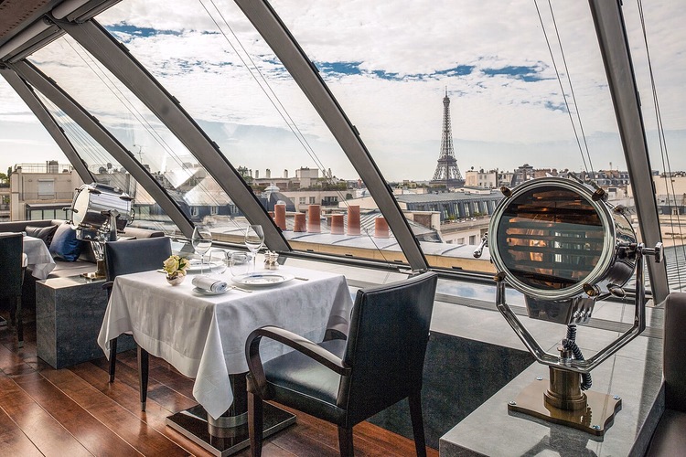 Eetzaal van een restaurant met uitzicht op de Eiffeltoren