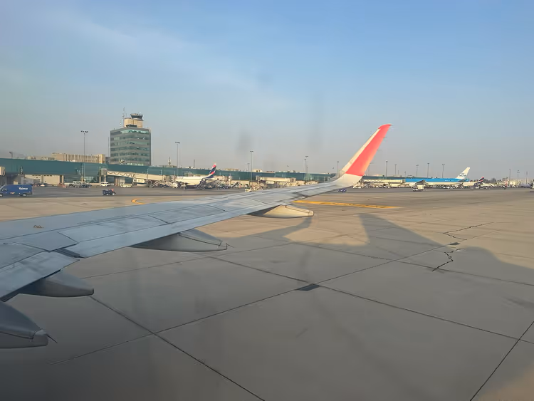 Flyvinge og flyplassterminal i det fjerne