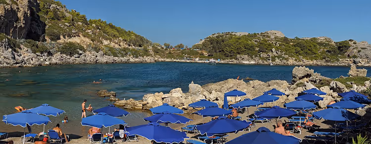 Ladiko Bay met blauwe strandparasols