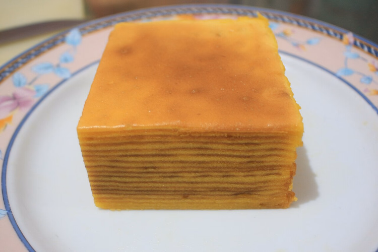 Stück geschichteter Spekkoek-Kuchen auf einem Teller