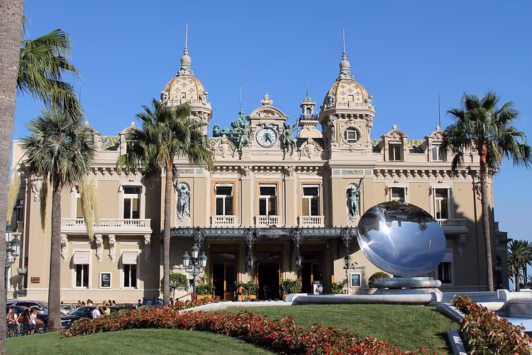 Fasaden til Monte Carlo-kasinoet med kupler og palmer