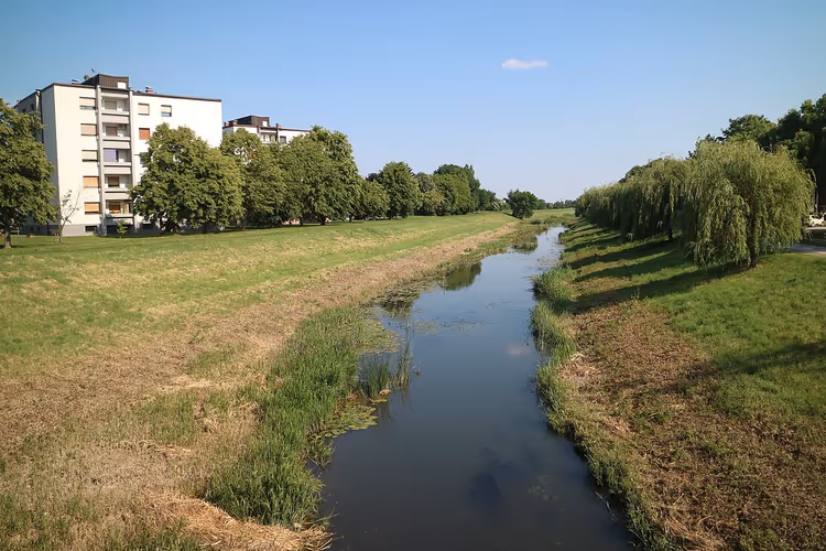 De rivier de Ledava met groene oevers en een huis