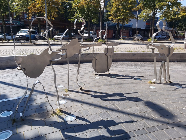 Stålsilhuetter av Beatles med gitarer på plassen