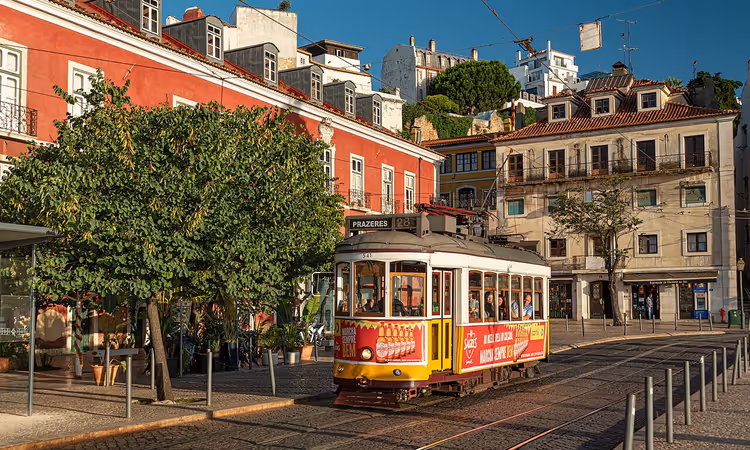 Gele historische tram in een straat in Alfama, Lissabon