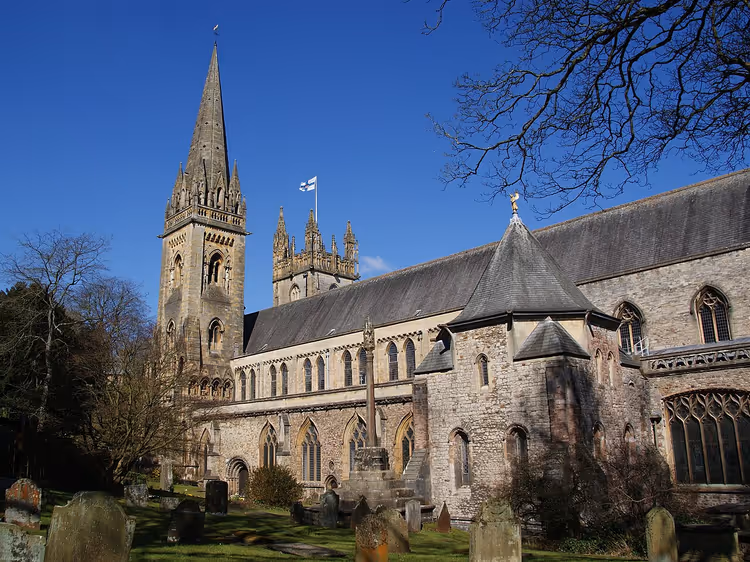 Llandaff Cathedral med høyt spir og gammel kirkegård