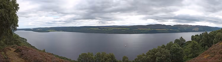 Tepeler ve bulutlarla Loch Ness panoraması