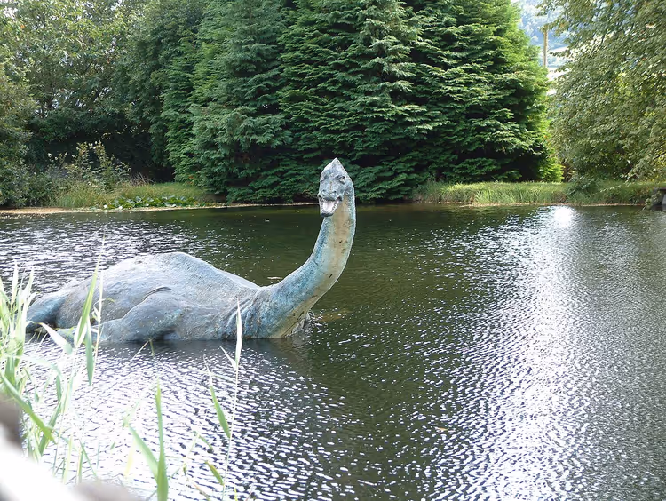 model van het Monster van Loch Ness in een vijver tussen de bomen