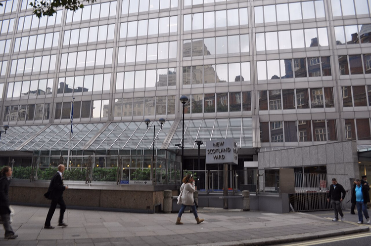 Enseigne du New Scotland Yard devant un immeuble de verre à Westminster