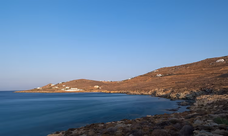 Una costa rocosa con aguas azules y colinas