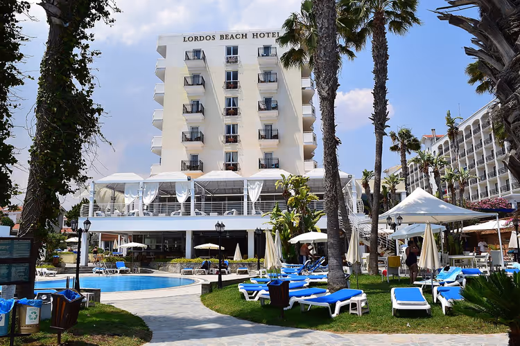 Lordos Beach hotel met zwembad, palmbomen en ligstoelen