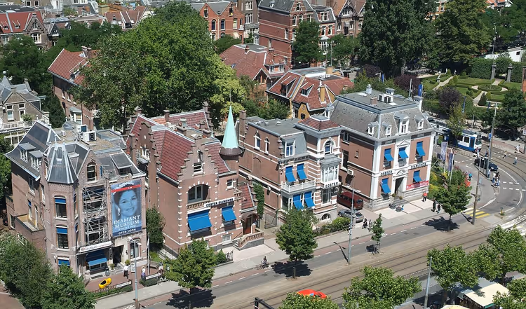 Luftfoto av en gate i Amsterdam med historiske bygninger og en trikk