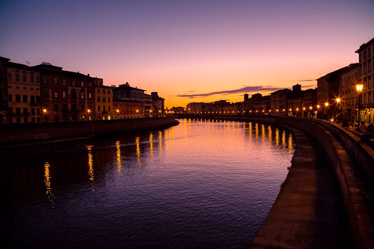 De Arno en de kade in Pisa bij zonsondergang