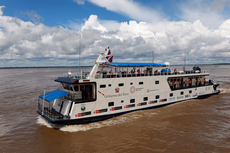 Hvit elvebåt på den gjørmete Amazonas i Iquitos